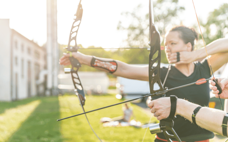 A crowded archery competition with cheering spectators and colorful targets